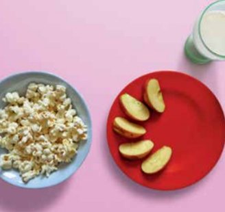 Popcorn and apple slices with a glass of mlik