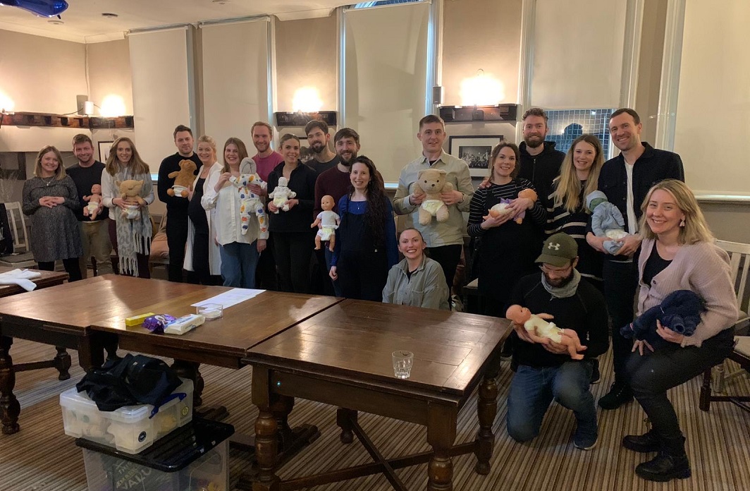 A group of mums, dads ad practice babies at an antenatal group