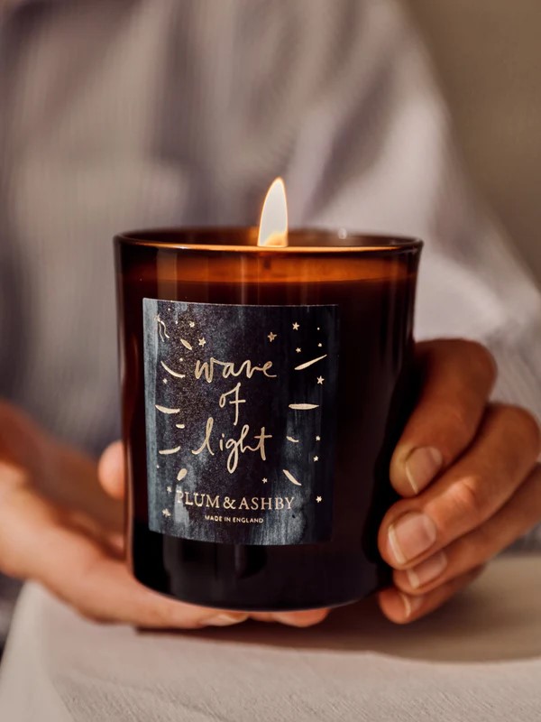 Close up of hands holding wave of light candle