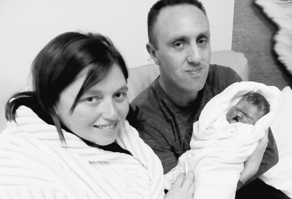 A black and white photo of a couple holding their stillborn baby in hospital