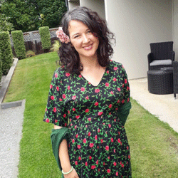 A photo of a pregnant woman smiling with a flower in her hair