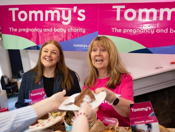 People hold an office cake sale for Tommy's