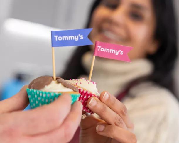 Photo of two delicious looking cupcakes, topped with Tea for Tommy's cake flags, chocolate buttons and icing